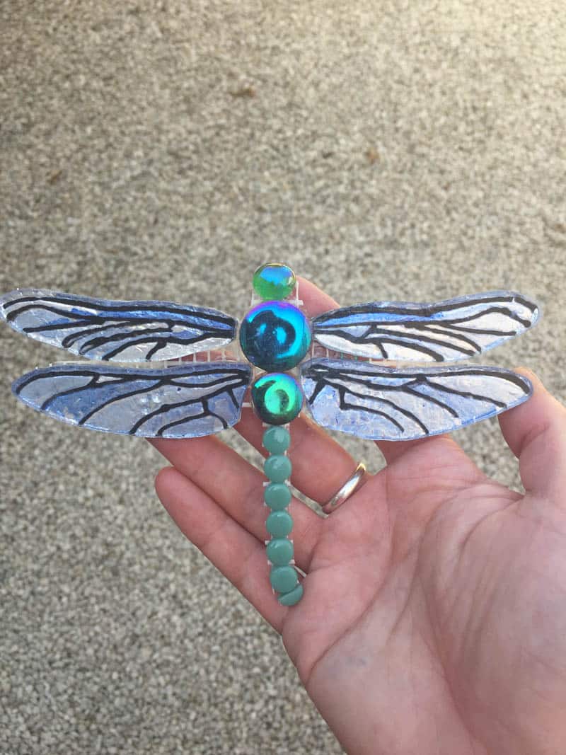 hand made mosaic dragonfly gift held in a hand ready for installation
