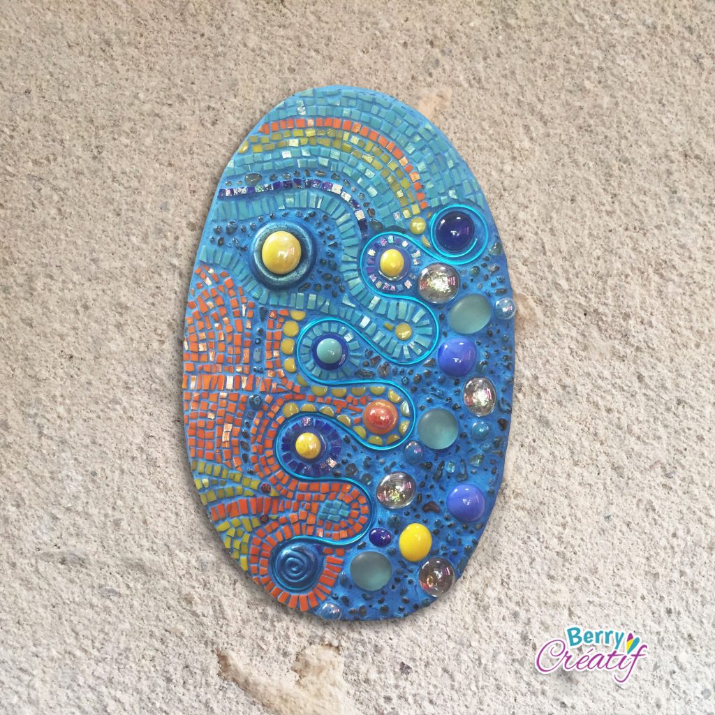 oval mosaic wall art with bright blue orange and yellow colours