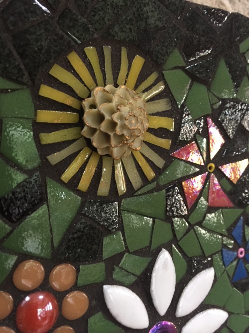 yellow flower made as part of a mosaic wall hanging