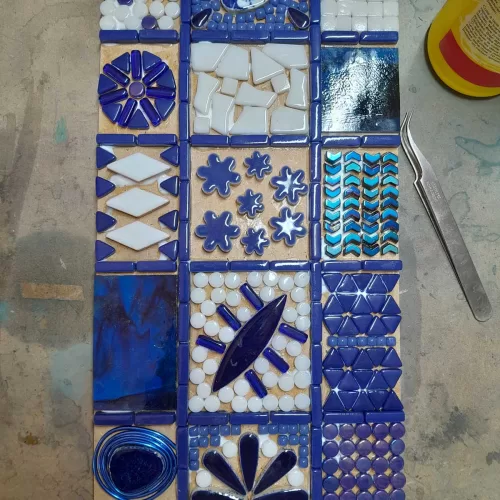 mosaic kit in progress, mosaic tiles being glued to the rectangular mdf board