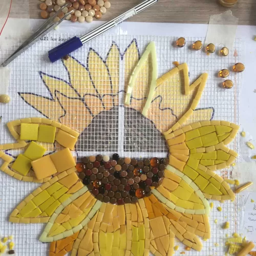 sunflower mosaic kit in progress, flower image shows in the background and directs the crafter to position the tiles