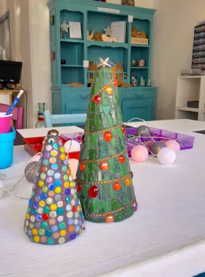 two christmas tree decorations in 3D sitting on a white table in mosaic workshop